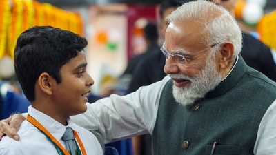 Prime Minister Narendra Modi interacts with school boy inside a coach of the Vande Bharat Express after flagging off four new train services, in Varanasi on Saturday.&nbsp; (DPR PMO)