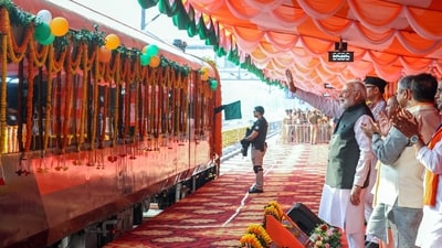 Prime Minister Narendra Modi waves to the passengers onboard the train after flagging off four new Vande Bharat Express train services at Banaras Railway Station, in Varanasi on Saturday.&nbsp; (Narendra Modi Photo Gallery )