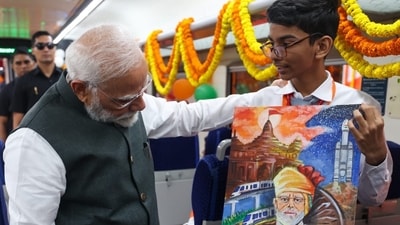 Prime Minister Narendra Modi interacts with school boy inside a coach of the Vande Bharat Express after flagging off four new train service. (S Kumar/HT Photo)