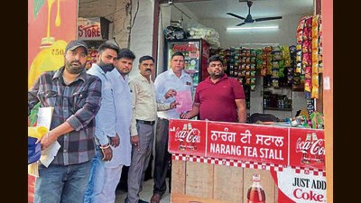 MC officials issuing challan to a trader in the city. (HT Photo)