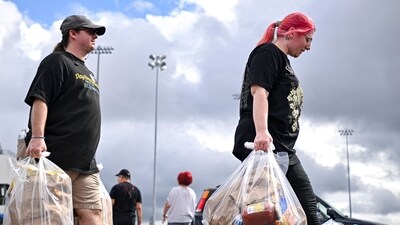 People carry bags of groceries during a free food distribution for recipients of the Supplemental Nutrition Assistance Program (SNAP). (AFP) People carry bags of groceries during a free food distribution for recipients of the Supplemental Nutrition Assistance Program (SNAP). (AFP)