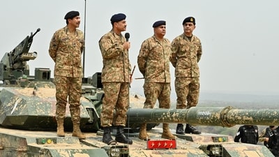 Chief of Army Staff of Pakistan Asim Munir holds a microphone during his visit at the Tilla Field Firing Ranges (TFFR) to witness an exercise (Reuters/File)
