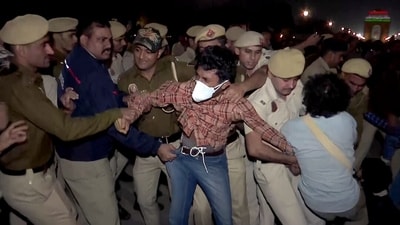 Police personnel detain a protester during the protest against rising air pollution at India Gate, in New Delhi on Sunday.&nbsp; (ANI Video Grab)