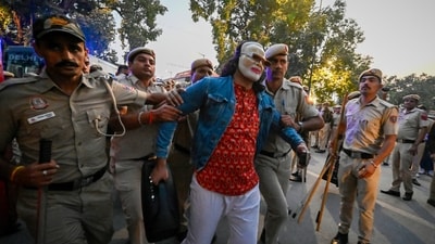 Delhi Police detain social activist who's wearing a Prime Minister Narendra Modi look-alike mask during the protest against the government over rising air pollution, near India Gate, Man Singh Road, in New Delhi, India, on Sunday, November 9, 2025. (Sanjeev Verma/HT photo)
