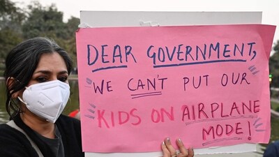 A woman wearing a mask holds a poster during a protest demanding the government take action to reduce air pollution in New Delhi on November 9, 2025.&nbsp; (AFP)