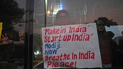 New Delhi was engulfed in a dense layer of smog on Monday, with an acrid smell lingering in the air as pollution levels spiked, worsening the city’s ongoing public health emergency. A detained demonstrator holds a placard from inside a police vehicle during a protest demanding the government take action to reduce air pollution.&nbsp; (AFP)