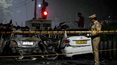 A police personnel inspects charred vehicles at the blast site after an explosion near the Red Fort in Delhi on November 10, 2025. (AFP) A police personnel inspects charred vehicles at the blast site after an explosion near the Red Fort in Delhi on November 10, 2025. (AFP)