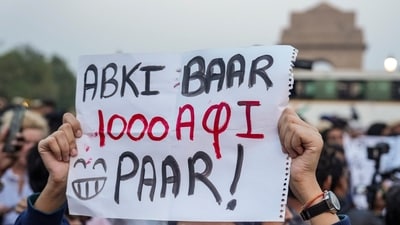 A demonstrator holds a placard, saying, “Abki Baar 1000 AQI Paar”, during a protest over the deteriorating air quality in the national capital region, in New Delhi, Sunday, Nov. 9, 2025.&nbsp; (PTI)