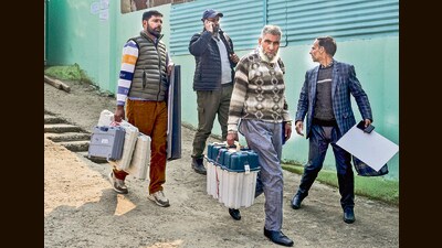 Polling officials carrying EVMs at a polling booth in Budgam on Monday. (PTI) Polling officials carrying EVMs at a polling booth in Budgam on Monday. (PTI)