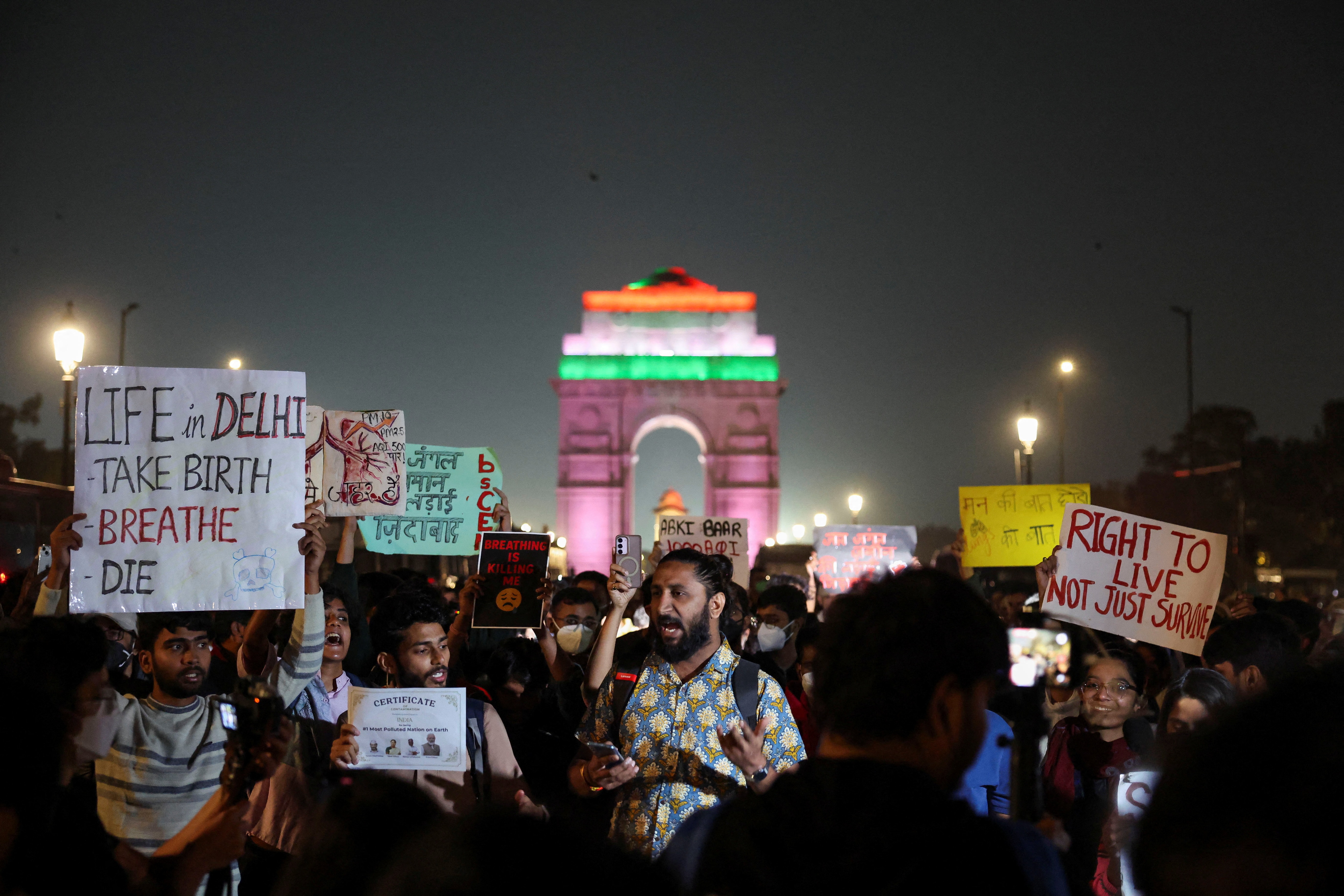 Protesters hold placards in front of the India Gate during a protest on the issue of air pollution in New Delhi on November 9, 2025. (Reuters Photo)
