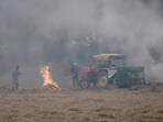 Farmers burn stubble in a field in Mansa on Tuesday. (REUTERS)