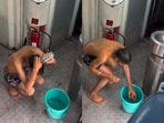 The video showed the passenger casually pouring water over himself and scrubbing in the open passageway just outside the toilet.