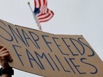 A man holds a sign reading "SNAP Feeds Families," as food aid benefits come under threat due to the ongoing U.S. government shutdown, during "A Rally for SNAP" on the steps of the Massachusetts Statehouse in Boston, Massachusetts, U.S., October 28, 2025. REUTERS/Brian Snyder/File Photo