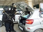 NSG and CISF personnel with a sniffer dog checking vehicles at an airport amid high alert following the Delhi car blast incident