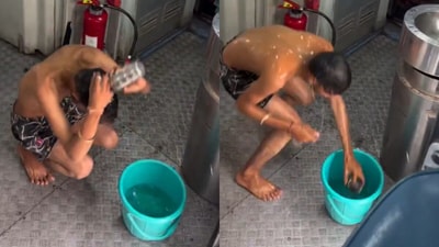 The video showed the passenger casually pouring water over himself and scrubbing in the open passageway just outside the toilet. (@CPRONCR/X) The video showed the passenger casually pouring water over himself and scrubbing in the open passageway just outside the toilet. (@CPRONCR/X)