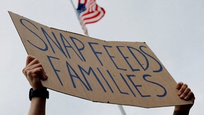 A man holds a sign reading "SNAP Feeds Families," as food aid benefits come under threat due to the ongoing U.S. government shutdown, during "A Rally for SNAP" on the steps of the Massachusetts Statehouse in Boston, Massachusetts, U.S., October 28, 2025. REUTERS/Brian Snyder/File Photo (REUTERS)