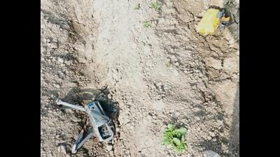 BSF personnel with the DJI Mavic 3 Classic drone, along with a packet of heroin, recovered from a field near Habibwala village in Ferozepur district on Thursday. (HT Photo)