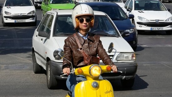 Merat Behnam drives her motorbike in Tehran on November 1, 2025. (AP)