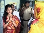 Bhartiya Janata Party candidate and singer Maithili Thakur greets a voter at the Alinagar polling booth.
