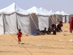 Children from El-Fasher rest outside their tent at a camp for displaced Sudanese people.