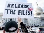 A protester holds a sign related to the release of the Jeffrey Epstein case files outside the U.S. Capitol on Wednesday.