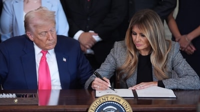 President Donald Trump watches as first lady Melania Trump adds her signature to an executive order. (AP) President Donald Trump watches as first lady Melania Trump adds her signature to an executive order. (AP)