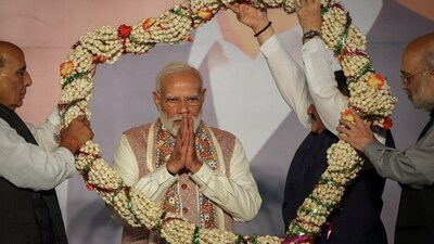 Home Minister Amit Shah and Defence Minister Rajnath Singh present a garland to Prime Minister Narendra Modi as BJP supporters celebrate the Bihar state assembly election results, at the party headquarters in New Delhi. REUTERS/Adnan Abidi