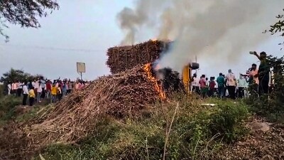 People look on as smoke billows from sugarcane on fire after several tractors and trolleys carrying sugarcane to a factory were allegedly set ablaze by miscreants, in Bagalkote. (PTI) People look on as smoke billows from sugarcane on fire after several tractors and trolleys carrying sugarcane to a factory were allegedly set ablaze by miscreants, in Bagalkote. (PTI)