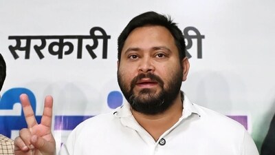 RJD leader Tejashwi Yadav with party leaders flashing victory sign during a press conference at his residence, Polo road in Patna, Bihar. (Santosh Kumar/HT Photo)