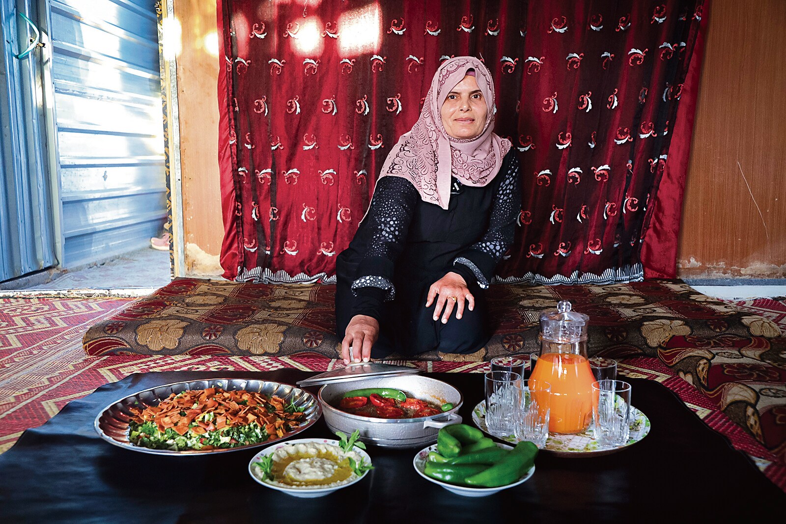 Layla, a 45-year-old Syrian refugee, poses with a typical Ramadan spread at her home in Zaatari. Food is served “with an eye to beauty,” Fisher says. (Photo: Shawkat Hesham al-Harfosh / Zaatari) Layla, a 45-year-old Syrian refugee, poses with a typical Ramadan spread at her home in Zaatari. Food is served “with an eye to beauty,” Fisher says. (Photo: Shawkat Hesham al-Harfosh / Zaatari)