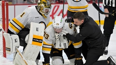 Boston Bruins defenseman Charlie McAvoy (73) is tended by a trainer and teammate goalie Jeremy Swayman (1) after receiving a shot in the mouth during the second period of the game against the Montreal Canadiens at the Bell Centre. (IMAGN IMAGES via Reuters Connect)