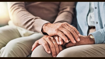 Holding hands, senior and couple with support in living room, empathy and love with care on couch. Lounge, marriage and people, elderly and retirement in house or apartment with compassion in home (Shutterstock) Holding hands, senior and couple with support in living room, empathy and love with care on couch. Lounge, marriage and people, elderly and retirement in house or apartment with compassion in home (Shutterstock)