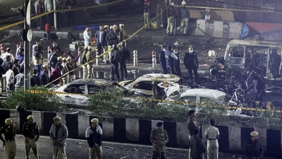 Police officers and forensic technicians work at the site of the blast in a Hyundai i20 car near Gate No. 1 of the Red Fort Metro station, in Delhi on Nov 10. (REUTERS)