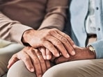 Holding hands, senior and couple with support in living room, empathy and love with care on couch. Lounge, marriage and people, elderly and retirement in house or apartment with compassion in home (Shutterstock)