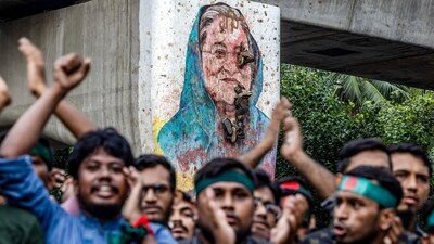Students chant slogans near a vandalised mural of Bangladesh's ousted Prime Minister Sheikh Hasina, during a protest demanding accountability and trial against Hasina, near Dhaka University in the capital on August 12, 2024. (AFP)