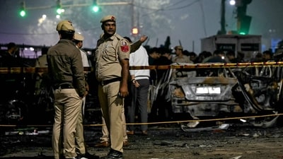 Police personnel stand beside charred vehicles at the blast site after an explosion near the Red Fort in the old quarters of Delhi. (AFP) Police personnel stand beside charred vehicles at the blast site after an explosion near the Red Fort in the old quarters of Delhi. (AFP)