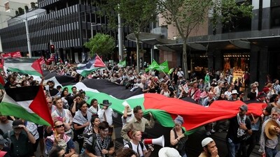 Demonstrators hold a large Palestinian flag during the 'Nationwide March for Palestine', after a ceasefire between Israel and Hamas in Gaza went into effect, in Sydney, Australia, October 12, 2025. REUTERS/Hollie Adams (REUTERS)