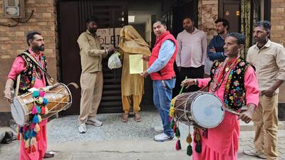 MC officials beating drums outside one of the offenders homes after she was caught red-handed tossing the garbage on the road. (HT Photo)