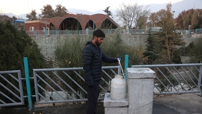 A man fills a water tank in Tehran, Nov. 14.