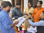 A Booth Level Officer explains the details of enumeration forms to citizens during the Special Intensive Revision of electoral rolls. (PTI) A Booth Level Officer explains the details of enumeration forms to citizens during the Special Intensive Revision of electoral rolls. (PTI)
