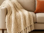 A snug throw placed with ease, bringing warmth, texture and gentle charm to a room that needs a quick seasonal refresh.(Ai Generated)