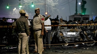 Police personnel stand beside charred vehicles at the blast site after an explosion near the Red Fort in the old quarters of Delhi. (AFP) Police personnel stand beside charred vehicles at the blast site after an explosion near the Red Fort in the old quarters of Delhi. (AFP)
