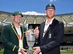 Australian captain Steve Smith (L) and England captain Ben Stokes hold the Waterford Crystal Ashes trophy