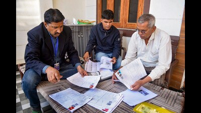 Booth Level Officers assist a voter in filling out the enumeration form for the SIR of electoral rolls in Bikaner, Rajasthan. (PTI)