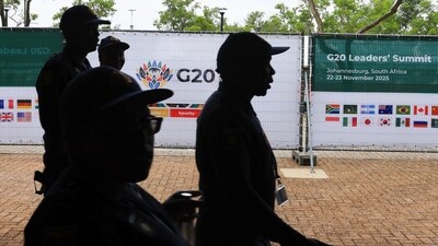 Police officers walks near G20 signs at the Nasrec Expo centre ahead of the G20 Summit, in Johannesburg, South Africa. (REUTERS)