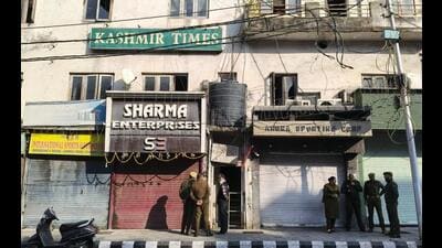 Police personnel outside the Kashmir Times office during a raid by the state investigation agency (SIA) on Thursday. (PTI Photo)