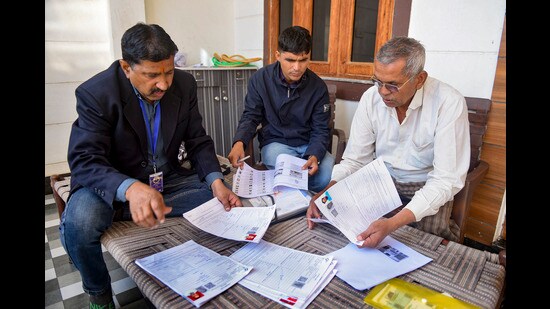 Booth Level Officers assist a voter in filling out the enumeration form for the SIR of electoral rolls in Bikaner, Rajasthan. (PTI)