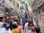 Residents stand in an alley after vacating their house next to a fallen scaffolding following an earthquake in Dhaka.