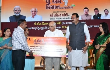 Gujarat Chief Minister Bhupendra Patel, with Agriculture Minister Jitu Vaghani and officials, hands over a PM-KISAN benefit approval letter to a beneficiary farmer at the state-level event in Gandhinagar. Gujarat Chief Minister Bhupendra Patel, with Agriculture Minister Jitu Vaghani and officials, hands over a PM-KISAN benefit approval letter to a beneficiary farmer at the state-level event in Gandhinagar.