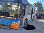 A HRTC bus stuck in a pit caused after a portion of the road caved in at Bhattakufer in Shimla on Saturday. (Deepak Sansta/HT) A HRTC bus stuck in a pit caused after a portion of the road caved in at Bhattakufer in Shimla on Saturday. (Deepak Sansta/HT)